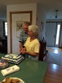 Dad and Mom getting advice on cutting their Anniversary cake